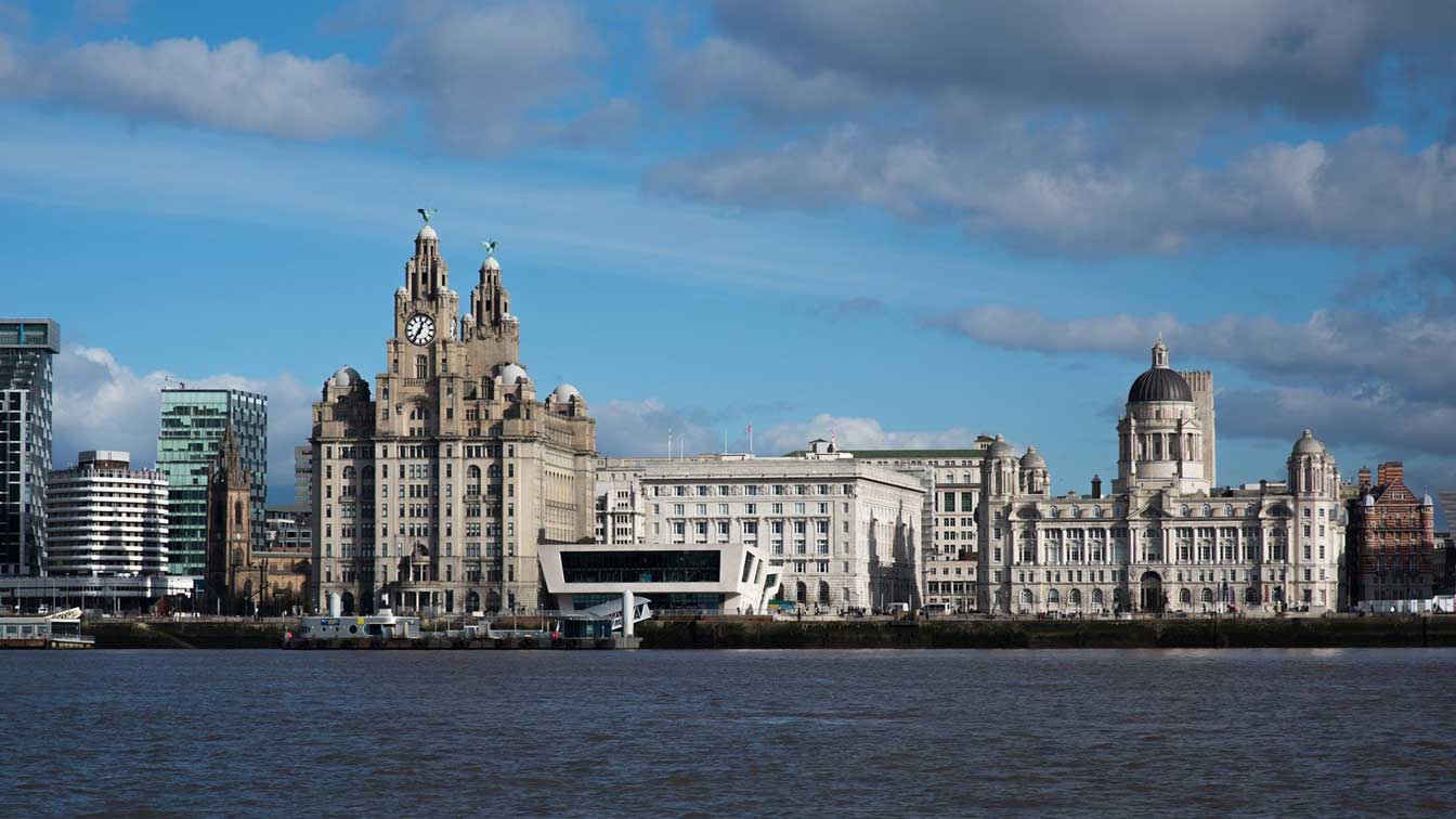 Liverpool cityscape by the river and liver building, Blog post UK Universities Surge Up World League Table, Fresh Global Alliance ,investment immigration visa in The United Kingdom, England, Scotland - Middle East, Dubai, Cairo.