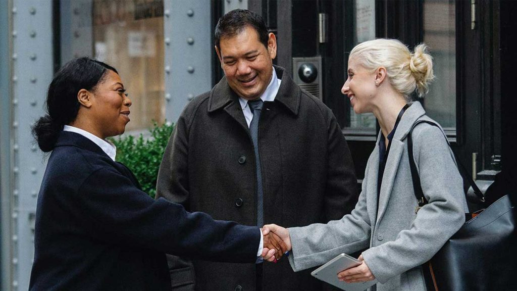 African woman, Asian man & a European woman shaking hands, Blog post The UK is a model to the world on diversity and multi ethnic community, Fresh Start UK, investment immigration visa in The United Kingdom, England, Scotland - Middle East, Dubai, Cairo.