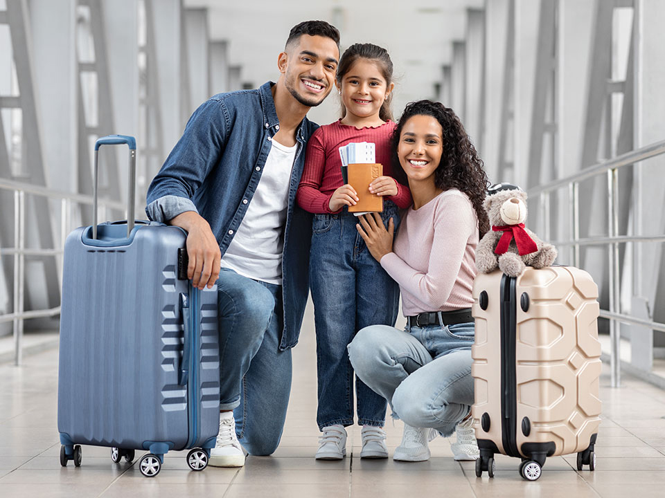 happy-middle-eastern-family-three-posing-airport-terminal-cheerful-arab-parents-their-cute-little-daughter-holding-suitcases-passports-tickets-smiling-camera-ready-travel